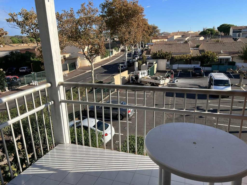 d'un balcon avec une table et une vue sur la rue. dans l'établissement PRIMAVERA Agréable T2 résidence avec piscine Plage Richelieu Cap d'Agde, au Cap d'Agde