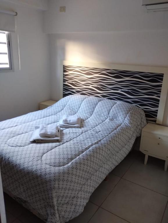 a bedroom with a bed with a blanket on it at Complejo calle Cordoba in General Roca