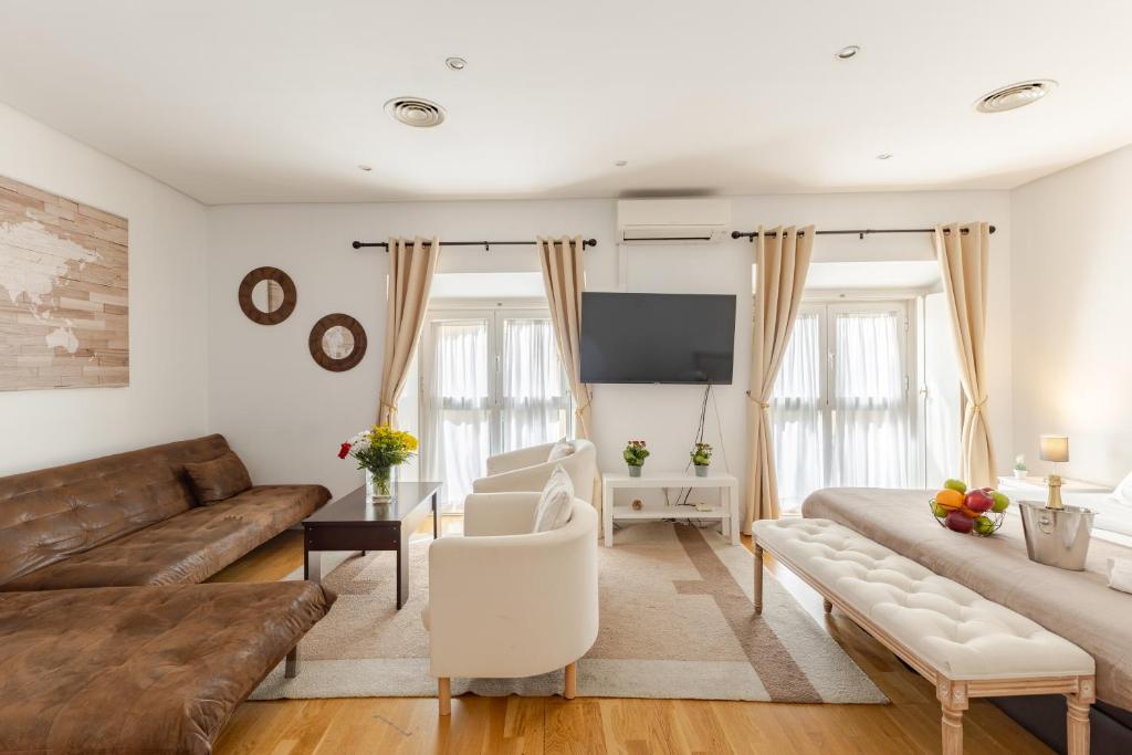 a living room with a couch and a tv at MAD COCO Aparts & Suites Centro Sol in Madrid