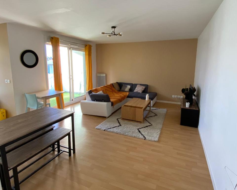 un salon avec un canapé et une table dans l'établissement Appartement moderne T3 Cesson, à Cesson-Sévigné