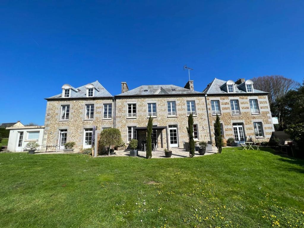 a large brick building with a green lawn at Clos Minotte 30 pers jacuzzi, billard, baby-foot in Tessy-sur-Vire