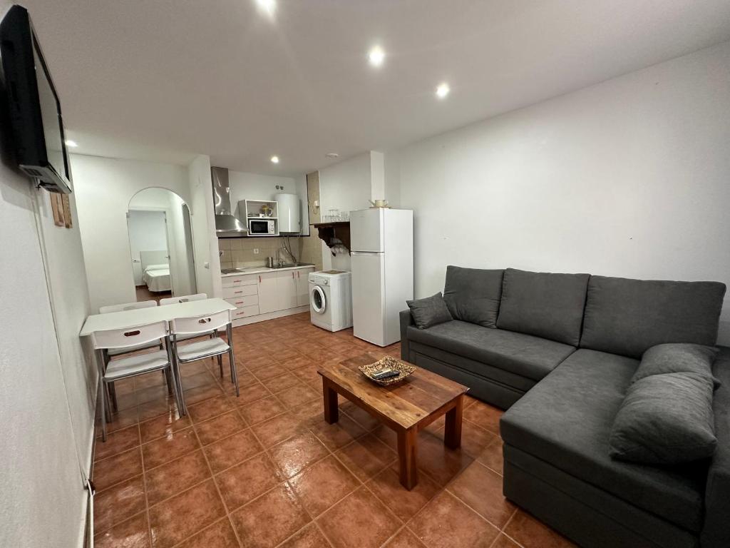 sala de estar con sofá y mesa en Apartamentos Alma de Zahara, en Zahara de los Atunes