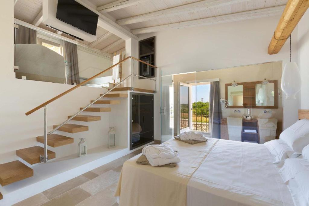 een slaapkamer met een groot bed en een trap bij Masseria Longa Boutique Hotel in Otranto
