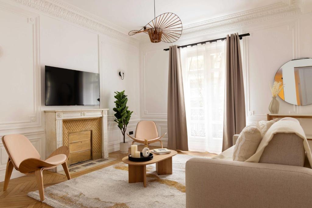 - un salon blanc avec un canapé et une cheminée dans l'établissement Cosy apartment - 3BR-6P - Montmartre-Sacré-Cœur, à Paris