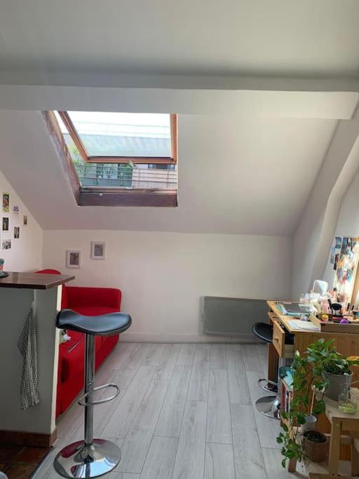 Cette chambre mansardée dispose de chaises, d'un bureau et d'une fenêtre. dans l'établissement Cosy studio Bastille, à Paris