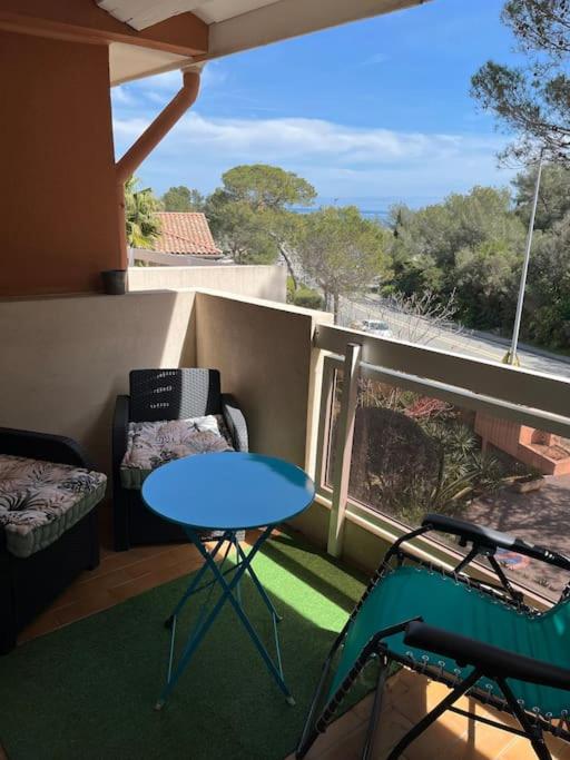 - un balcon avec une table bleue et 2 chaises dans l'établissement Cocon Familial, à Saint-Raphaël