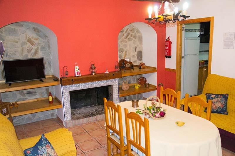 uma sala de estar com uma mesa e uma lareira em Cortijo Villarosa em Benablón