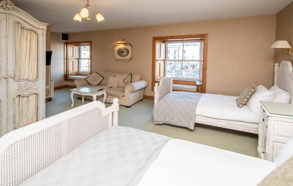 a bedroom with two beds and a living room at The Ormond Apartments in Dungarvan