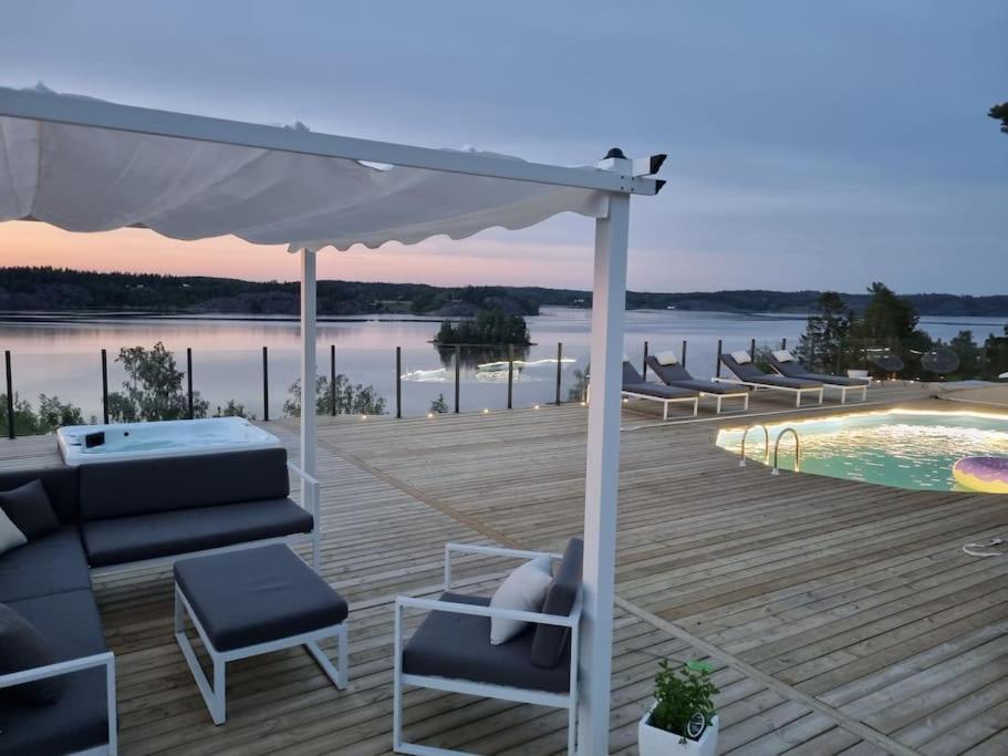 una terraza con sofá, sillas y piscina en House by the sea, en Söderköping