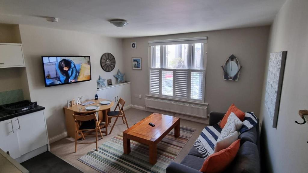 a living room with a couch and a table at St Margaret's Ground Floor and Lower Deck Apartment in Ryde