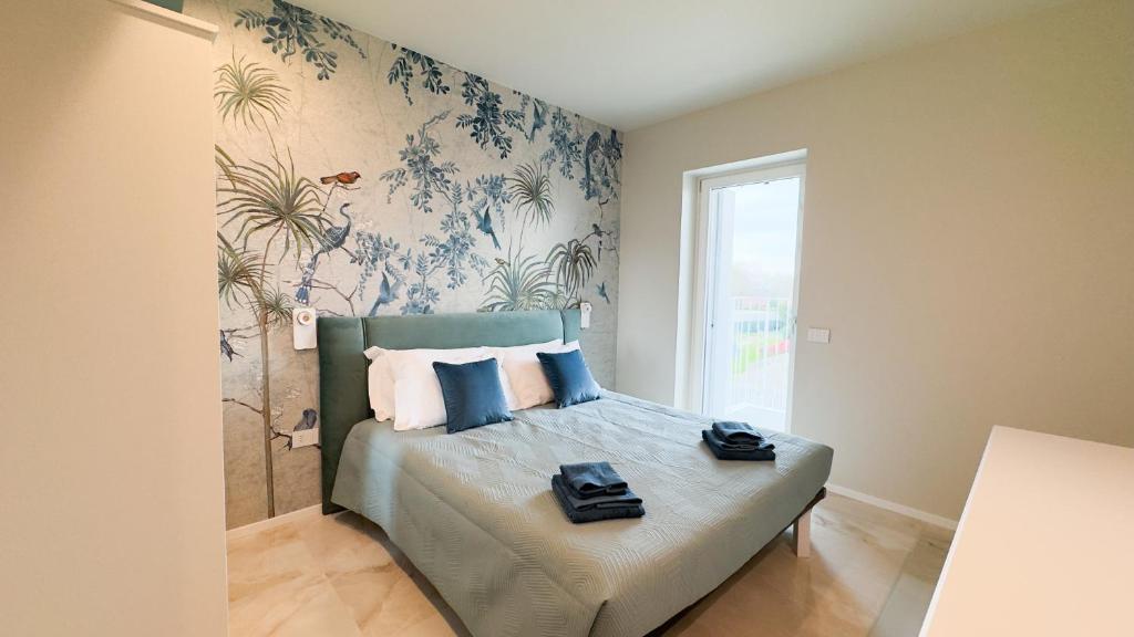 a bedroom with a bed with blue and white wallpaper at Farmont Seafront Acquamarine Suite by CaSa Check in Chioggia