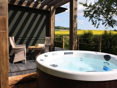 a hot tub on a deck with a table and chairs at The Chilterns View in Wallingford