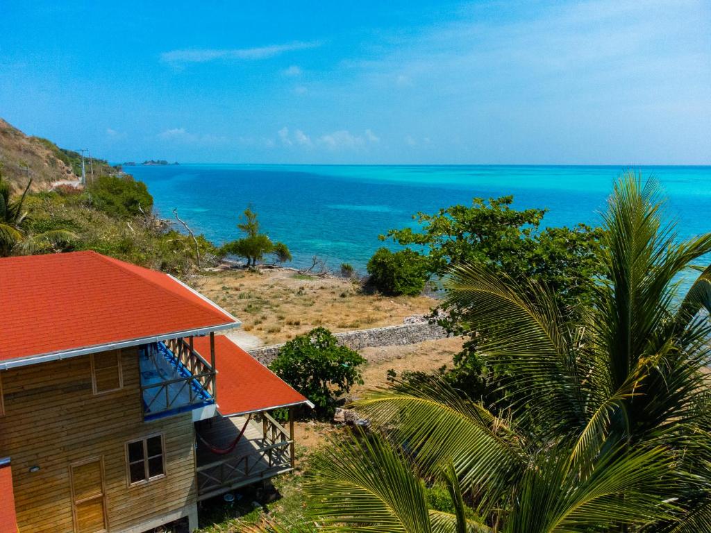 dom z pomarańczowym dachem nad oceanem w obiekcie Kalaloo Point w mieście Providencia