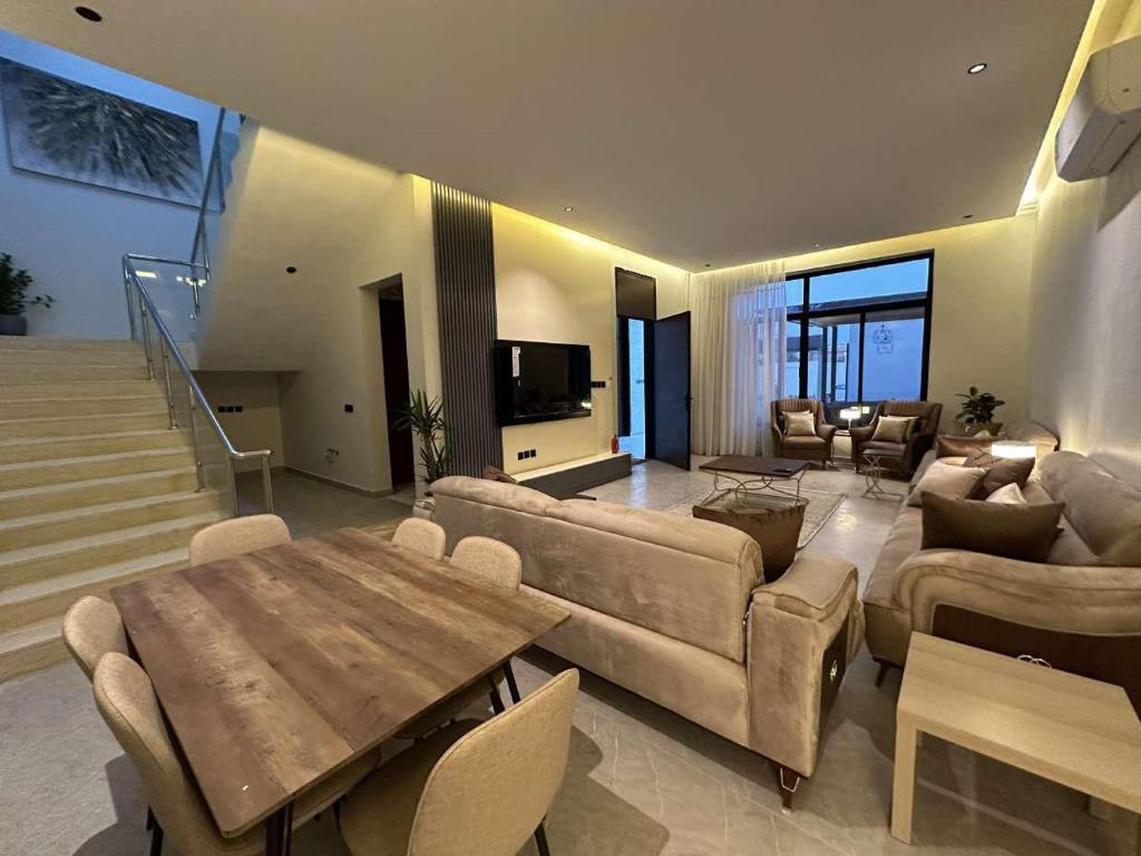 ein Wohnzimmer mit einem Sofa und einem Tisch in der Unterkunft ابيات فيلا in Riad