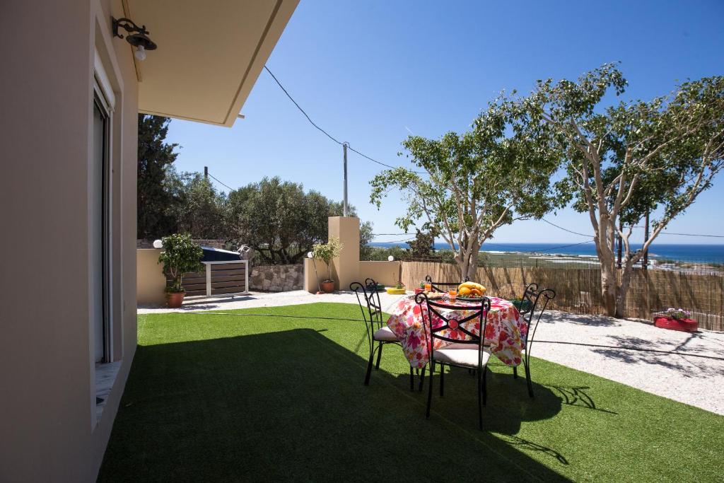 une table et des chaises sur une pelouse avec vue sur l'océan dans l'établissement Falasarna Nice House, à Falasarna