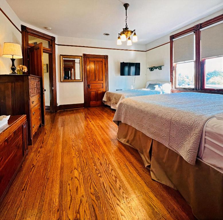 una camera con 2 letti e un pavimento in legno di The Villa on Meridian a Indianapolis