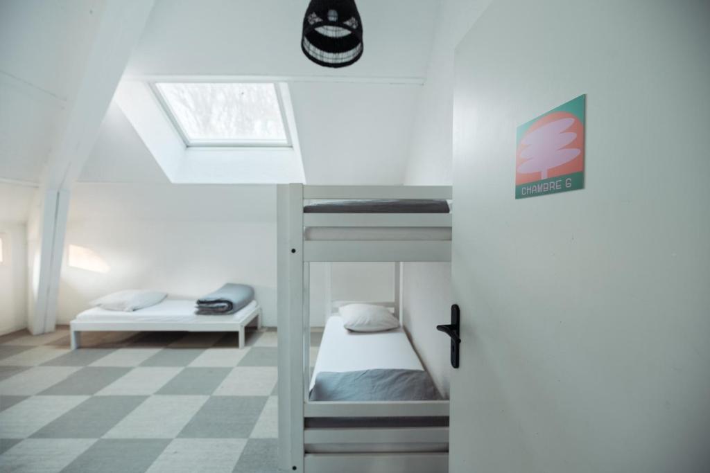 a bedroom with bunk beds and a checkered floor at Gîte de groupe "La Donaclaudré" pour vos événements en pleine nature - 15 à 120 personnes proche de Disneyland Paris in Saint-Augustin