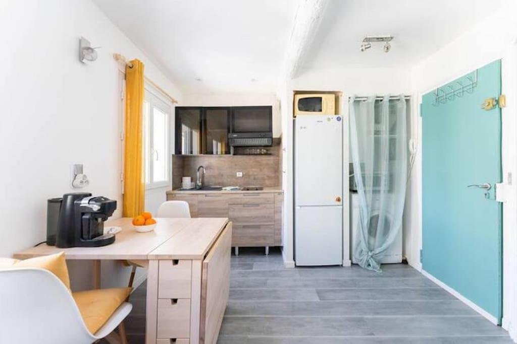 a kitchen with a white refrigerator and a table at Coste Investissement - Le Perchoir in Marseille