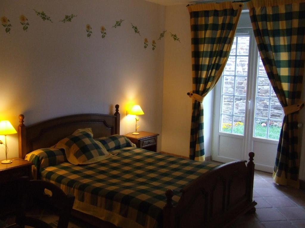 a bedroom with a bed and a large window at Les Abris de la Sée in Tirepied