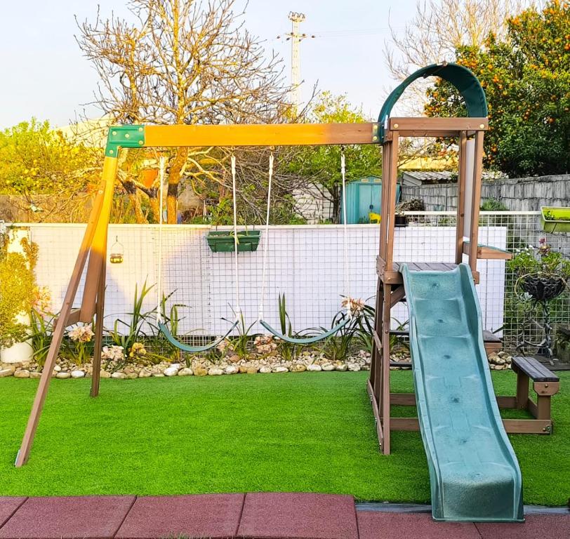 a playground with a slide in a yard at Herama Sea Guesthouse in Vila Nova de Gaia