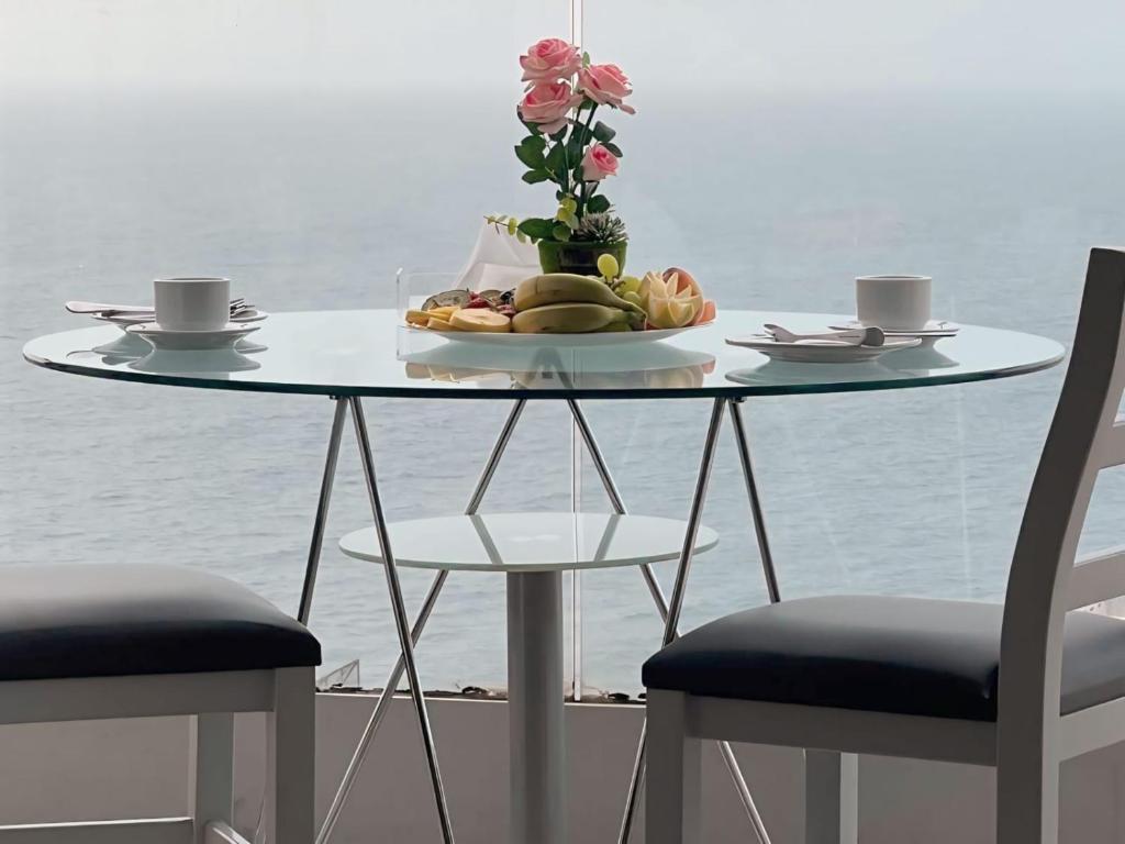 uma mesa com um prato de frutas e duas cadeiras em Ny Suites em Beirute