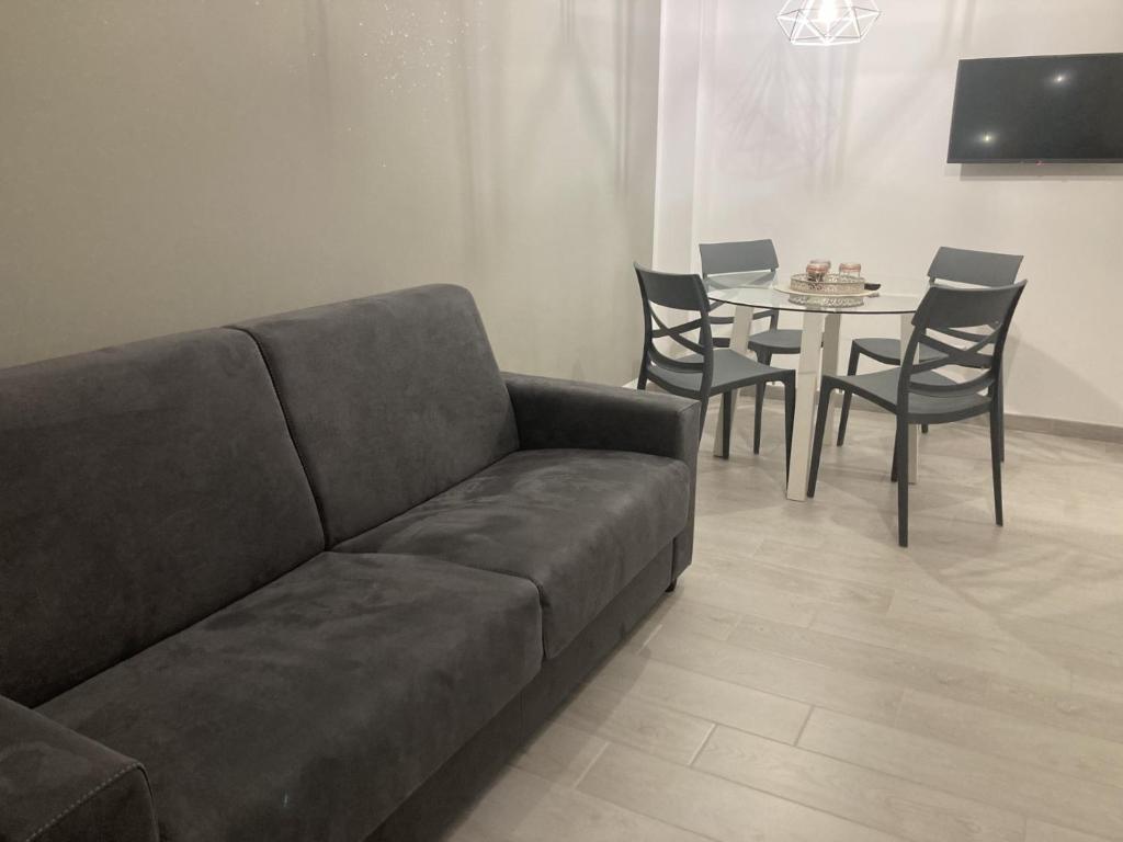 un soggiorno con divano e tavolo con sedie di La Casa di EMMA a Corsico