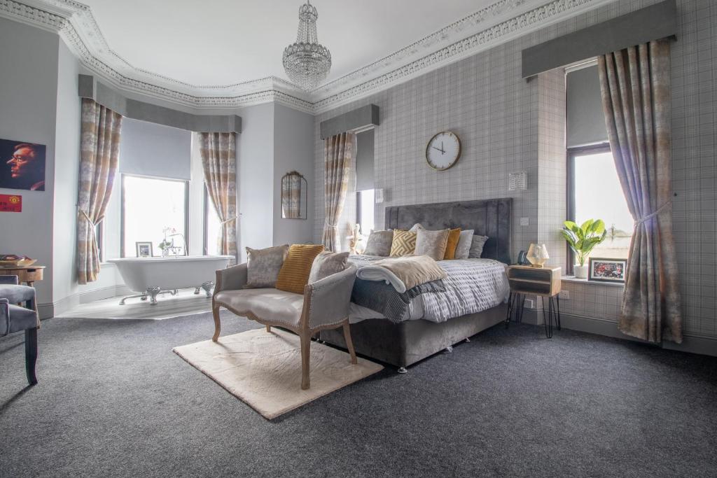 a bedroom with a bed and a bath tub and a sink at Lugton Rooms in Beith