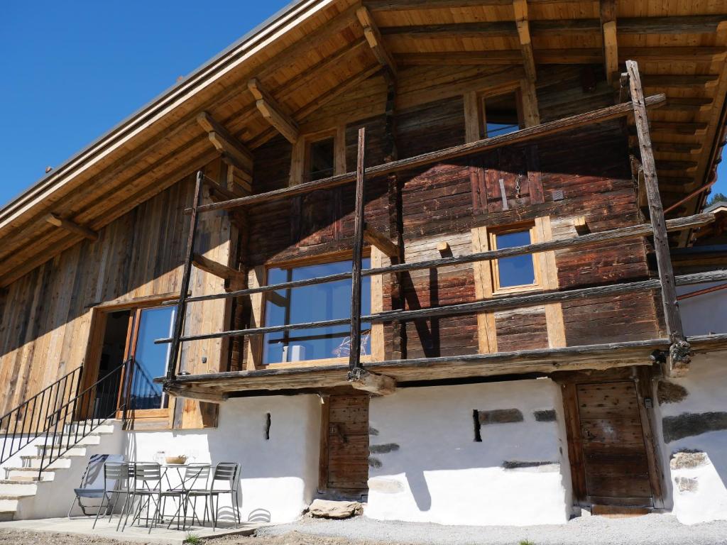 ein Holzhaus mit einem Balkon an der Seite in der Unterkunft La ferme d'Hauteluce - Chalets in Hauteluce