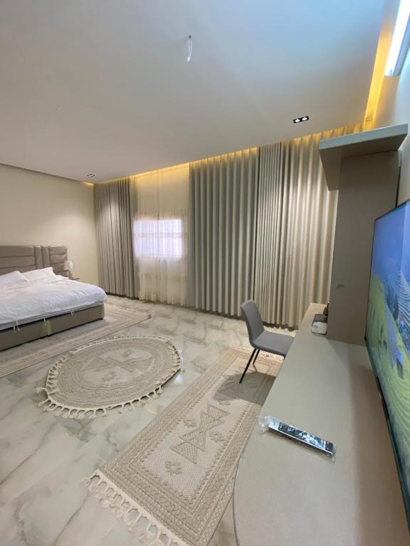 a bedroom with a bed and a tv and a desk at مشار العلا AL ULA in AlUla