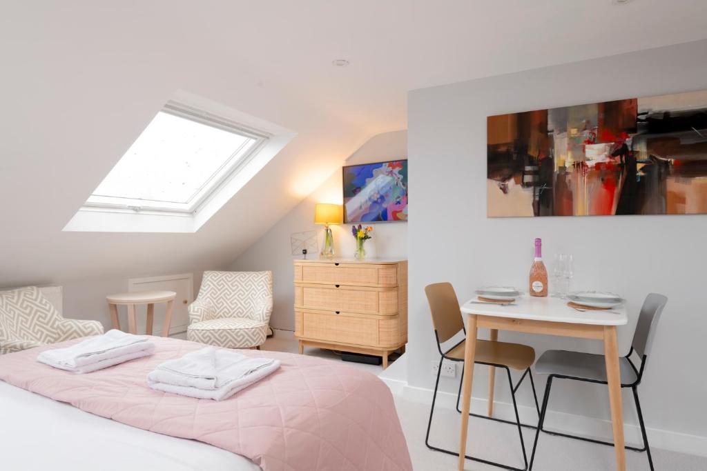 a bedroom with a bed and a table and a chair at Cosy Loft Retreat, King Bed, En-suite, Kitchenette, Homestay in Brighton & Hove