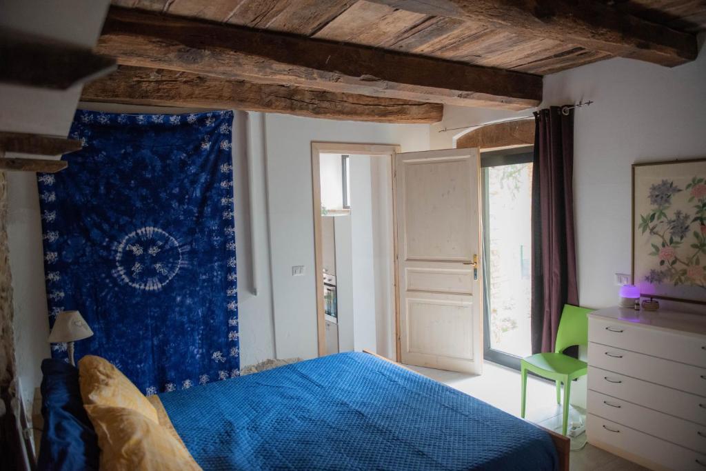 - une chambre avec un lit bleu et une fenêtre dans l'établissement La casa del Colle, à San Ginesio