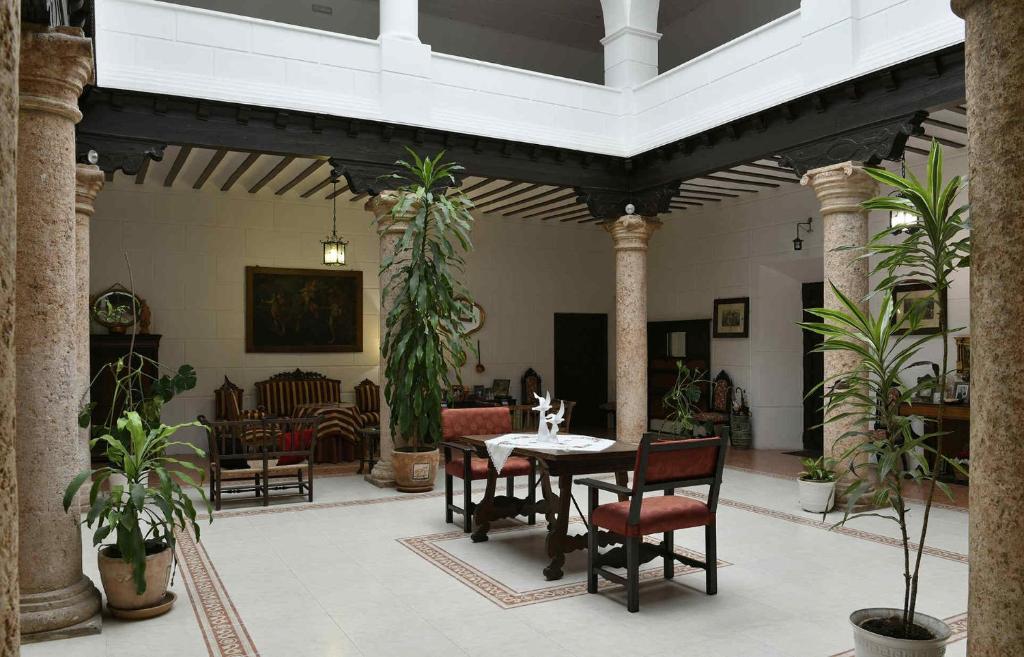 une salle à manger avec une table, des chaises et des plantes dans l'établissement Casa de los Acacio, à San Clemente