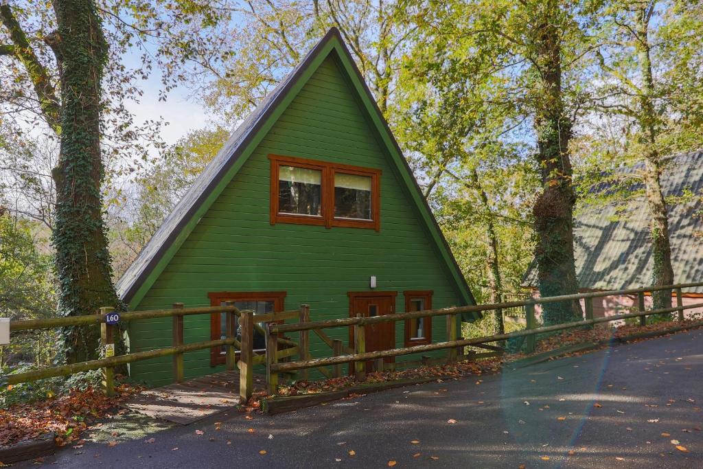 a green house with a gambrel roof at Hazel Bank A-Frame Holiday Property in Devon in Chudleigh