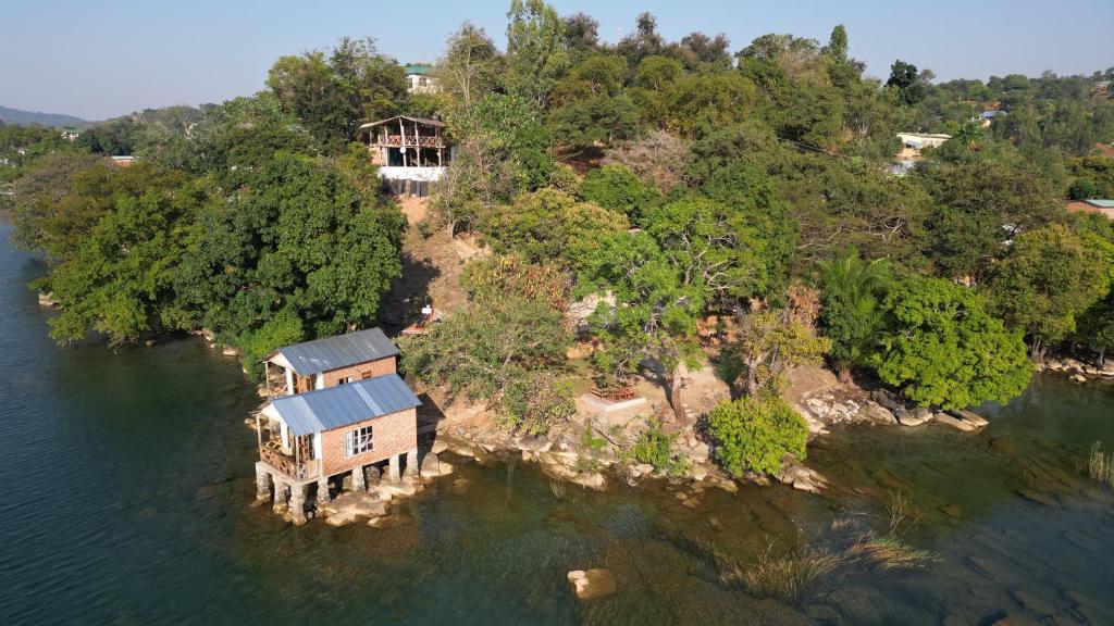 eine Insel im Wasser mit einem Haus darauf in der Unterkunft Soul Rebel Lodge & Backpackers in Nkhata Bay
