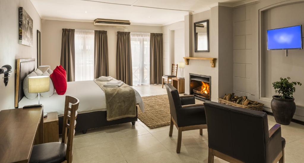 a hotel room with a bed and a fireplace at Clanwilliam Hotel in Clanwilliam