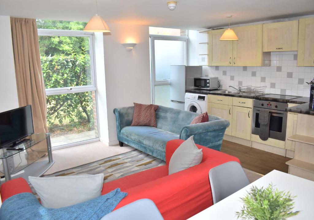 a living room with a couch and a kitchen at Chichester Quarters - Ground Floor, City Centre, 2 Bedroom Apartment in Chichester