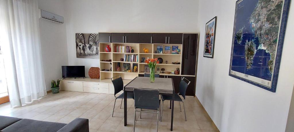 uma sala de estar com uma mesa com cadeiras e uma televisão em Casa vacanze Carbonia "Nala", 4 posti letto, IUN R8334 em Carbonia