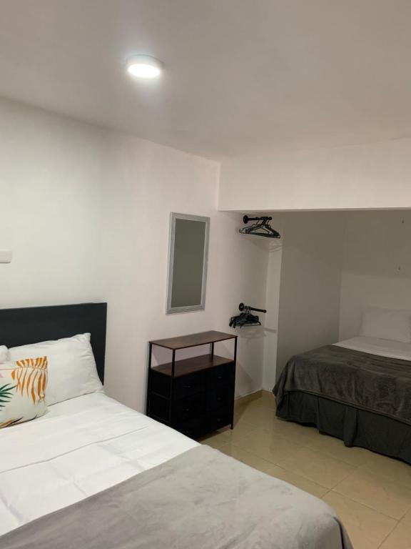 Habitación de hotel con cama y espejo en HILLMON'S HOTEL BAR LOUNGE, en Sosúa