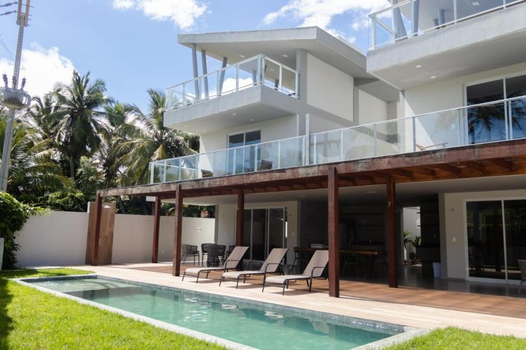 a villa with a swimming pool and a house at Casas Refúgio da Barra in Barra Grande