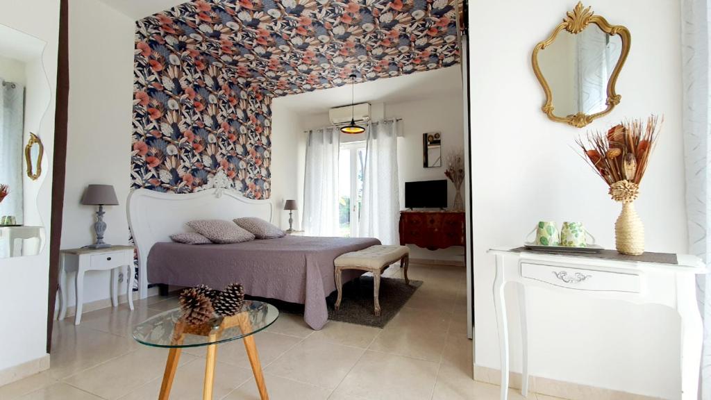 Schlafzimmer mit einem Bett und einem Tisch mit einem Spiegel in der Unterkunft Chambres d'Hôtes Etang de l'aiguille in Oeyreluy