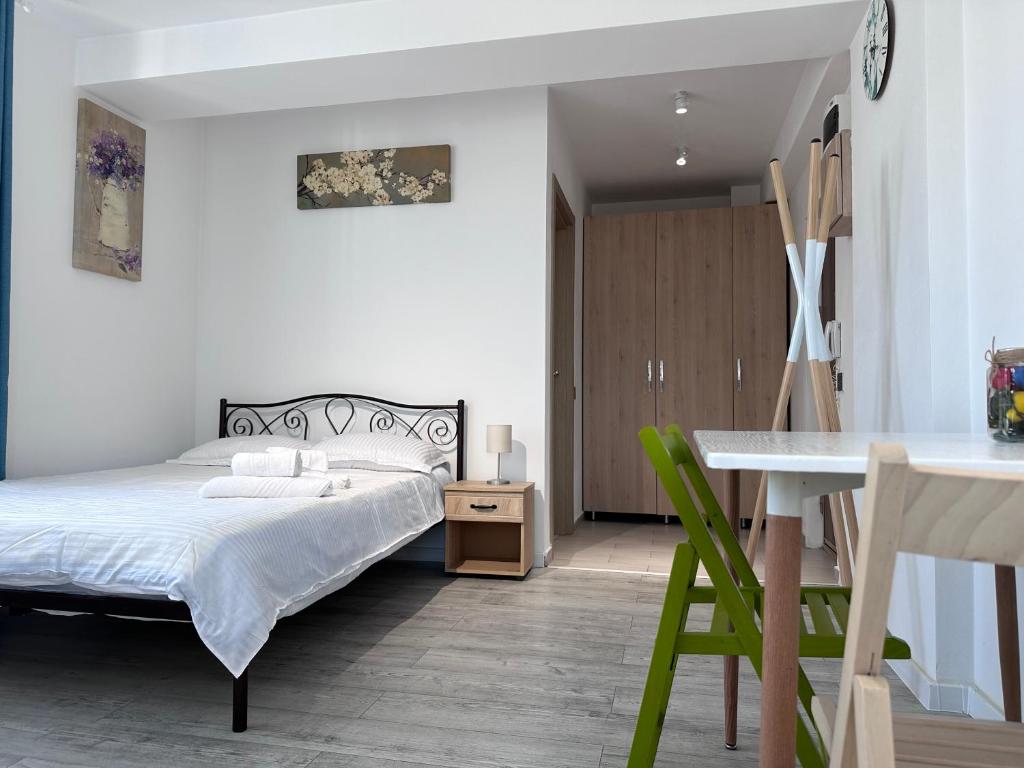 a bedroom with a bed and a table and a desk at Diamant residence - self check in & free parking in Bragadiru
