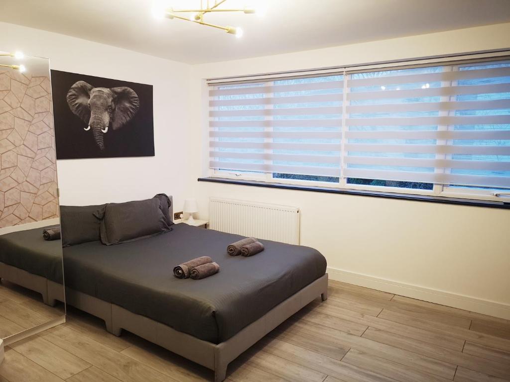 a bedroom with a bed and a large window at Stylish Studio minutes away from Wembley in London