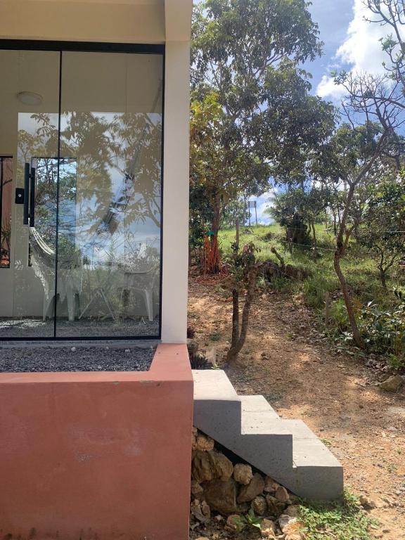 a house with a glass window and stairs on the side at Chales Estrela Veadeiros in Alto Paraíso de Goiás