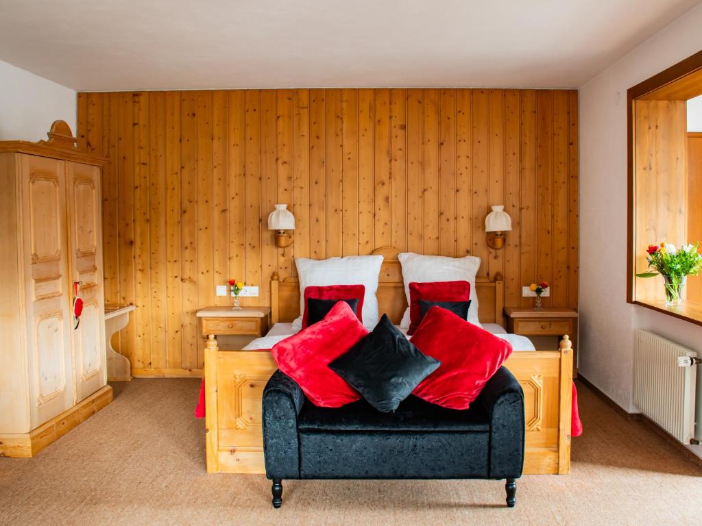 Schlafzimmer mit einem Bett mit roten und schwarzen Kissen in der Unterkunft Schwarzwald Hotel Wiedenerhof in Wieden