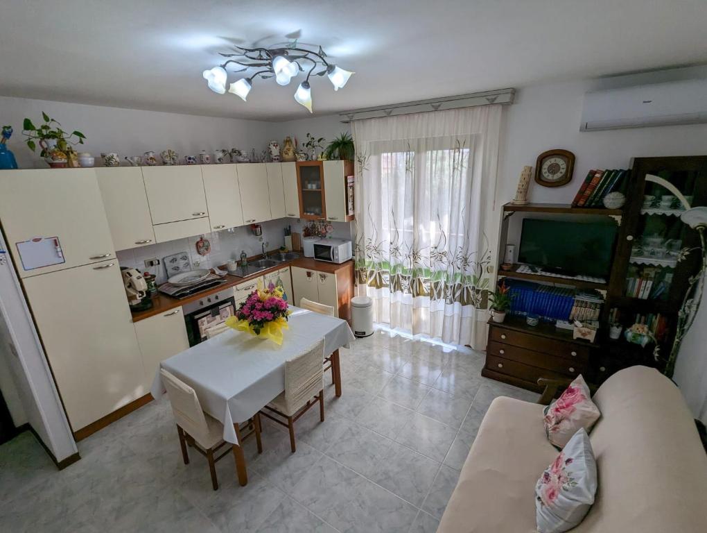 uma cozinha e sala de estar com uma mesa e uma televisão em Casa Vacanze Cuore di Maremma em Il Bagno