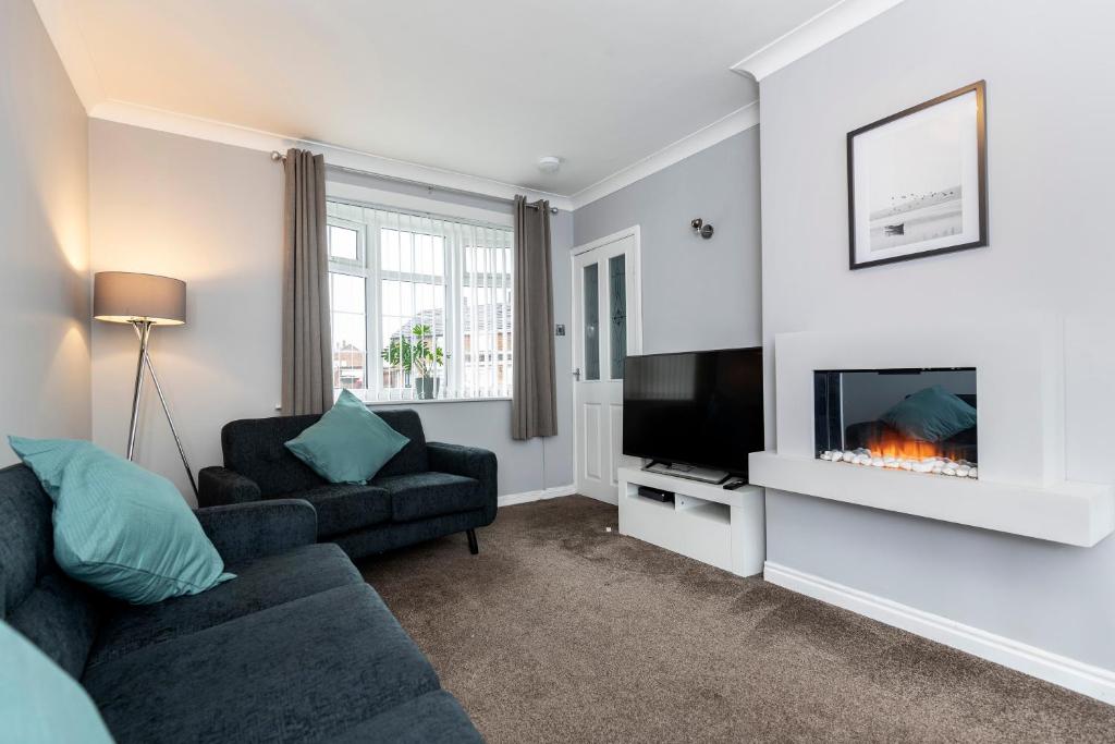 a living room with a couch and a fireplace at Park Green in Stockton-on-Tees