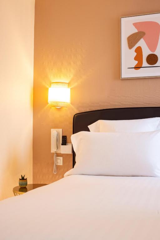 Postel nebo postele na pokoji v ubytování Hôtel Le Nautilus