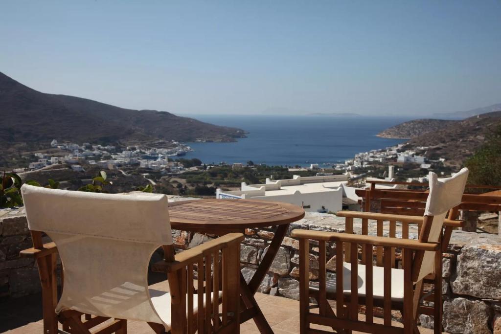 a wooden table and chairs on a balcony with a view at Skopelitis Village in Katapola
