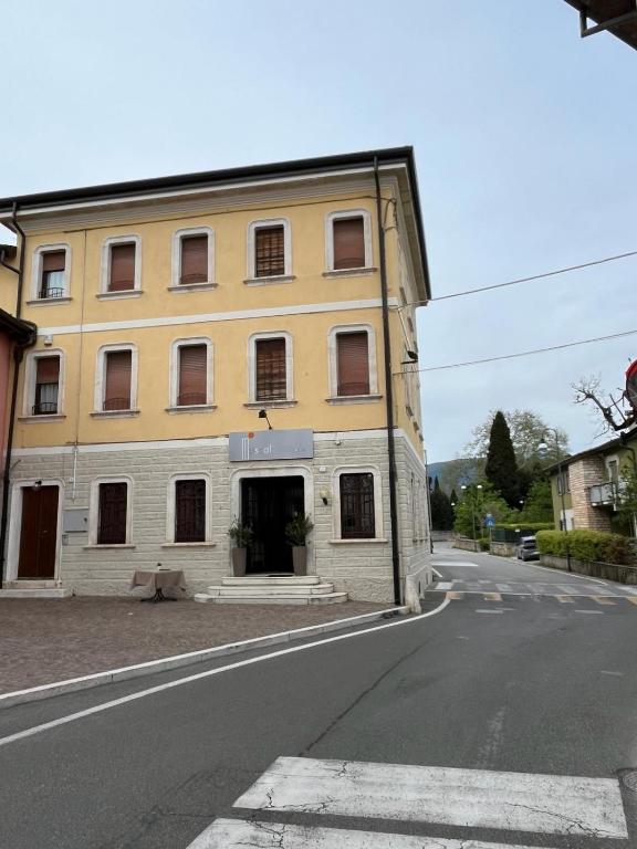 ein gelbes Gebäude am Straßenrand in der Unterkunft Locanda Moscal in Affi