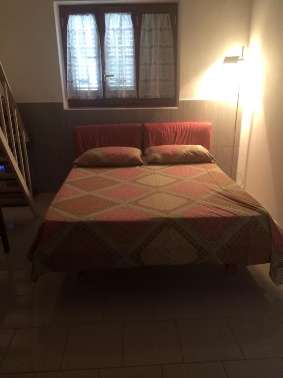 un letto in una camera da letto con lampada e finestra di Casa Vacanze Mare Trinitapoli a Trinitapoli